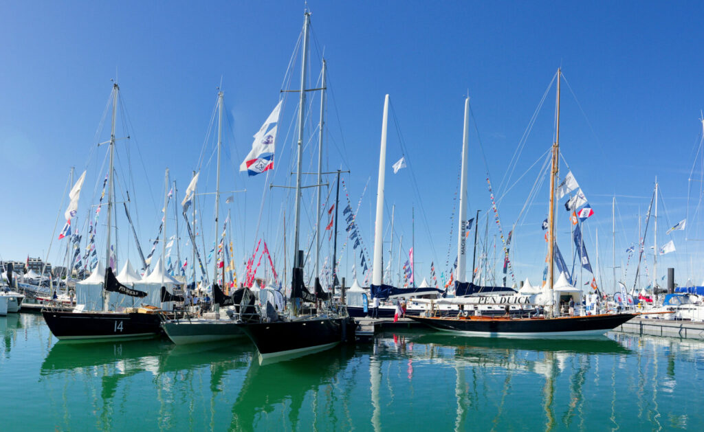 Voiliers Pen Duick amarrés à un quai, avec des drapeaux colorés